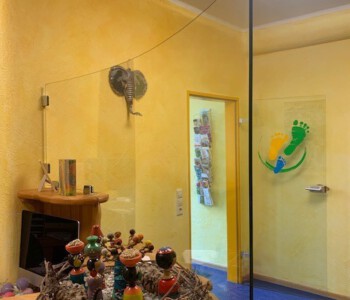 Gebogenes Einscheibensicherheitsglas 8 mm an die Biegung des Empfang-Tresens angepasst und mit Glasklemmhaltern befestigt.